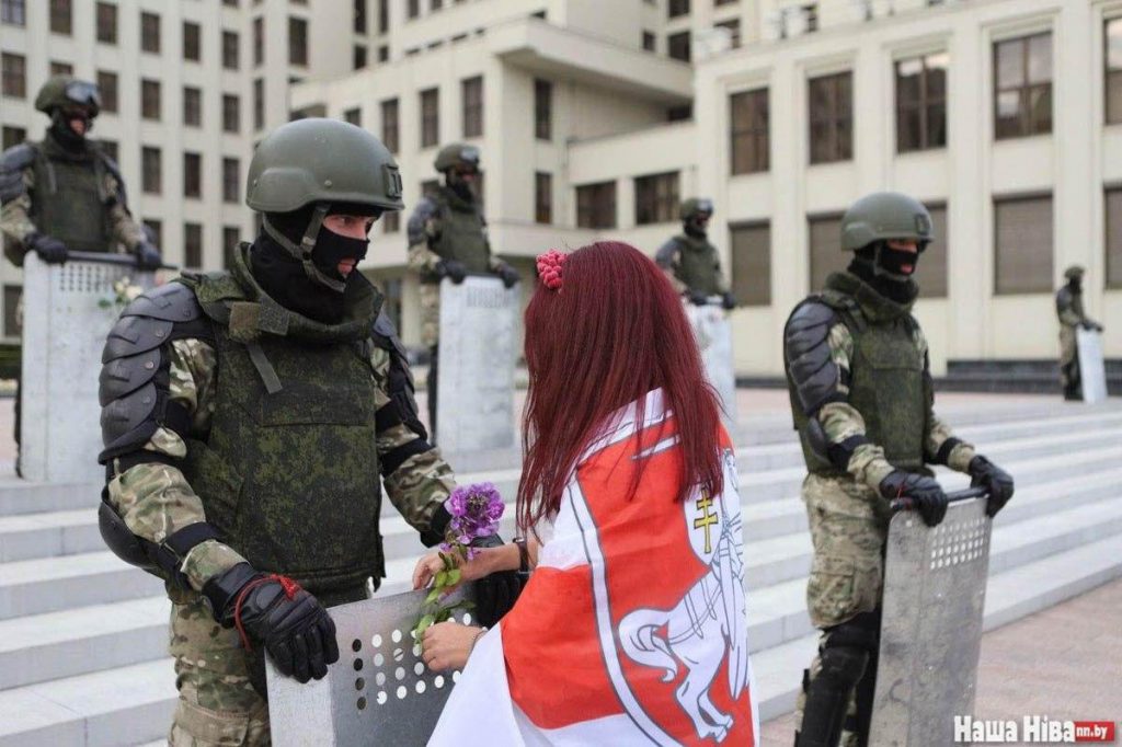 Protestująca obdarowuje policjanta kwiatkami